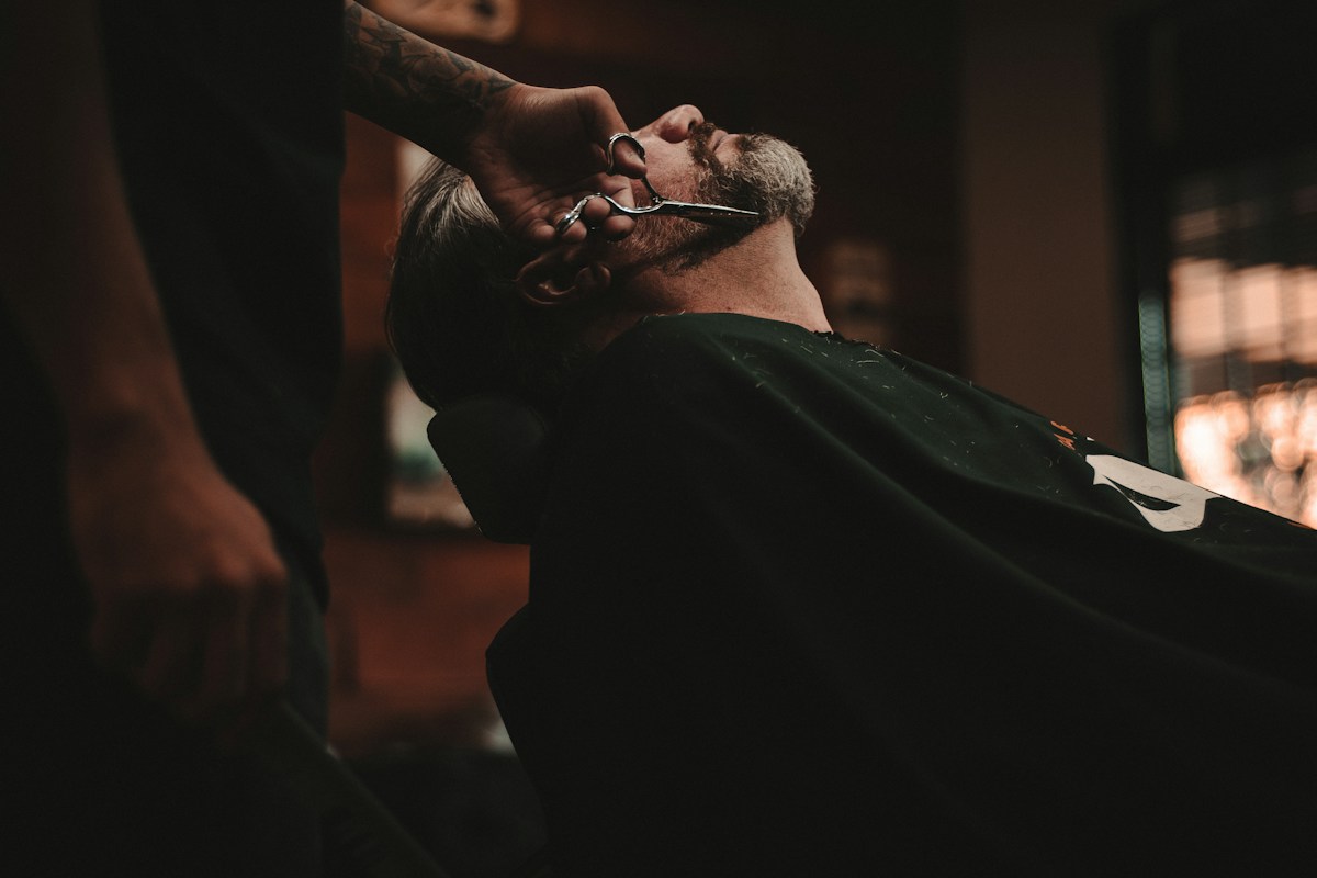 Barbeiro cuidando da barba de um cliente